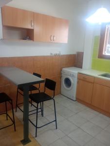 a kitchen with a table and a washing machine at Rallis village in Akrata