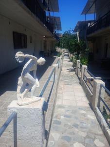 a statue of a boy leaning against a rail at Rallis village in Akrata