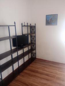 a living room with a tv on a shelf at Rallis village in Akrata