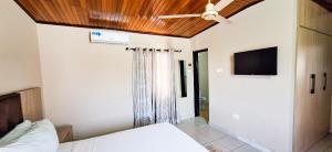a bedroom with a bed and a flat screen tv at First Choice Hotel in Accra +27 photos