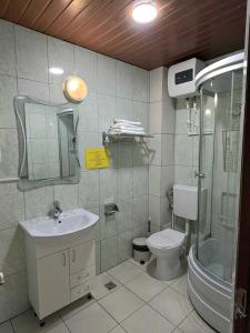a bathroom with a sink and a toilet and a shower at Asia Hotel in Târgu Jiu