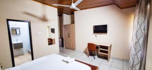 a hotel room with a bed and a television at First Choice Hotel in Accra