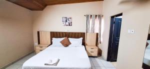 a bedroom with a large bed with white sheets at First Choice Hotel in Accra