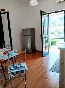 a room with a table and a chair and a refrigerator at Ioannis Foteinos Studios in Lygia