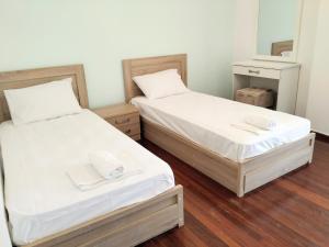 two beds in a room with white sheets at Ioannis Foteinos Studios in Lygia