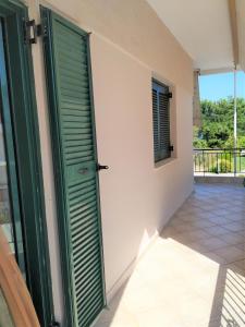a room with a green door and a balcony at Ioannis Foteinos Studios in Lygia