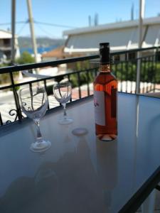 a bottle of wine and two wine glasses on a table at Ioannis Foteinos Studios in Lygia