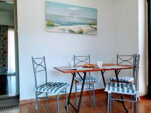 a dining room table and chairs with a painting on the wall at Ioannis Foteinos Studios in Lygia +1 photo