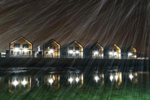 a row of houses on the water at night at Risøyhamn Sjøhus AS in Risøyhamn