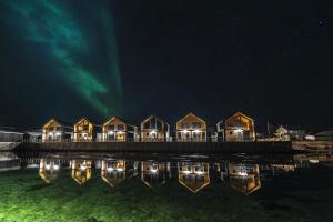 a row of houses on a dock at night at Risøyhamn Sjøhus AS in Risøyhamn
