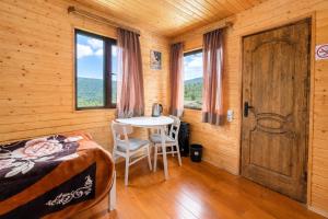 a bedroom with a bed and a table with chairs at Ushguli Cabins l Cafe in Ushguli +34 photos