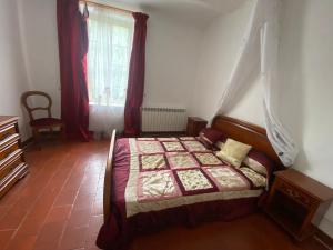 a bedroom with a bed and a window at Le cadeau bleu, duplex en Cévennes in La GrandʼCombe +3 photos