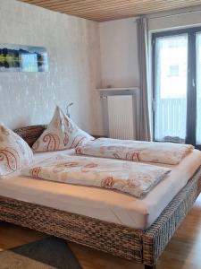 two beds sitting in a room with a window at Apartment mit Seeblick - Hopfen am See in Füssen +17 photos