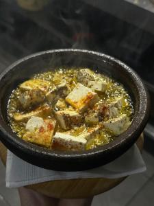 a person holding a bowl of soup with tofu at Trojet e Mija in Theth +22 photos