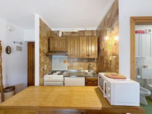 a kitchen with wooden cabinets and a counter top at Cesa Fraines - Apt 28 in Alba di Canazei +16 photos