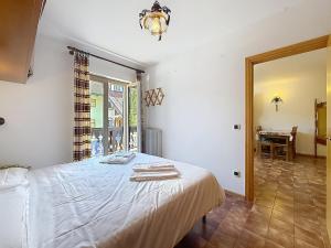 a bedroom with a bed and a table and a window at Cesa Fraines - Apt 28 in Alba di Canazei