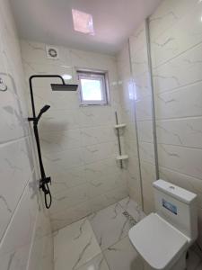 a white bathroom with a toilet and a window at PaNORAMA TSALKa in Tsalka