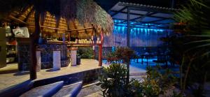a restaurant with a bar with surfboards in a room at Hotel Carmen Costa Coral in Tambor