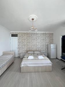 a bedroom with two beds and a brick wall at Zuri Kvariati in Kvariati +34 photos