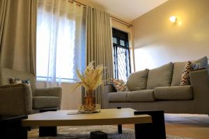 a living room with a couch and a table at Kingram Apartments in Entebbe