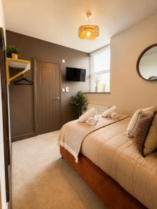 a bedroom with a bed and a tv on the wall at Lilac Cottage in Barnard Castle