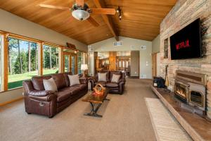 a living room with leather furniture and a stone fireplace at River Heights Home cabin in Leavenworth