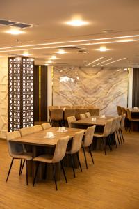 a restaurant with tables and chairs in a room at فندق بلازا أثينيه Plaza Athenee Hotel in Kuwait