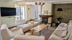 a living room with a couch and a fireplace at Gîte de la Verdière Spa Pool Valley in Le Sourn