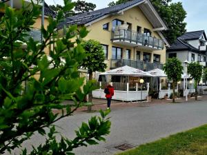 a woman walking down a street in front of a building at Apartment Nordstern in Baabe