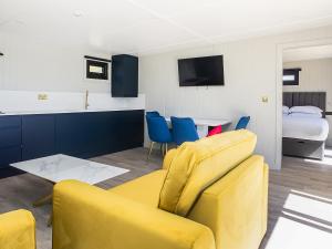 a living room with a yellow couch and blue chairs at Nightingale Lodge - Uk51938 in Yarm