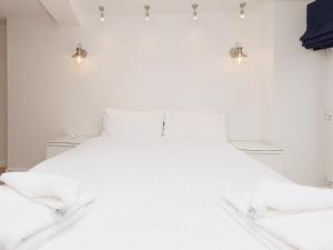 a bedroom with a white bed with lights on the wall at Ferrydown in Salcombe