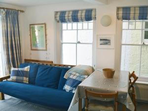 a blue couch in a living room with a table at Ferrydown in Salcombe