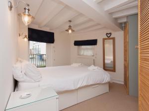 a bedroom with a white bed and a mirror at Ferrydown in Salcombe