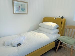 a bed with pillows on it next to a chair at Wolf Bear Tor in Bamford