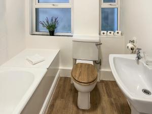 a white bathroom with a toilet and a sink at Wolf Bear Tor in Bamford