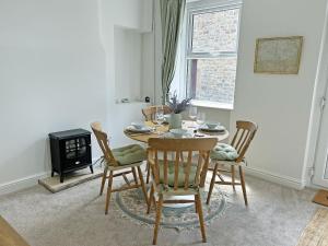 a dining room with a table and four chairs at Wolf Bear Tor in Bamford