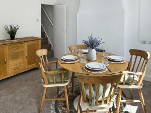 a dining room with a wooden table and chairs at Wolf Bear Tor in Bamford +7 photos