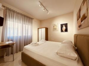 a bedroom with a large bed and a window at Thoma's K Studios in Vlorë +177 photos