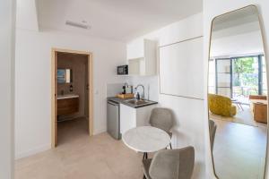 a kitchen with a table and chairs and a mirror at Eden Islands Marseille Prado in Marseille