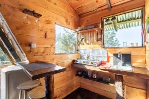 a kitchen in a log cabin with a counter and a sink at Jaulares Glamping in Alaska