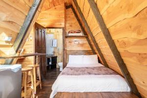 a bedroom in a log cabin with a bed at Jaulares Glamping in Alaska