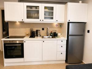 a kitchen with white cabinets and a stainless steel refrigerator at Seaside Nest in Kythira
