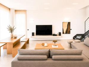 a living room with a couch and a tv at Miguel Luxury Beach Front Villa in Fánai