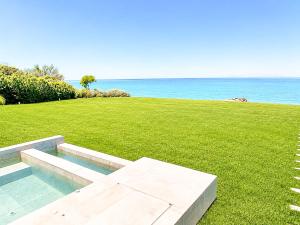 a bench in a field with the ocean in the background at Miguel Luxury Beach Front Villa in Fánai