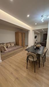 a dining room with a couch and a table and chairs at Sweet Nest in Paralia Katerinis