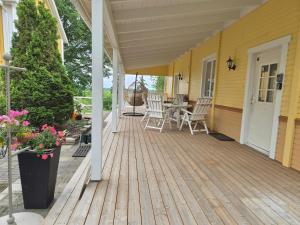 a porch of a yellow house with a table and chairs at Pihatalo in Seinäjoki