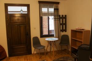 a room with a door and two chairs and a table at Casa Kővár Vendégház in Rimetea
