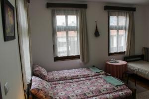 a bedroom with a bed and a table in it at Casa Kővár Vendégház in Rimetea +4 photos
