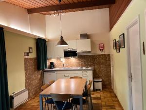 a kitchen with a table and chairs in a room at Le Renard - Oignies 50 in Petit Mesnil