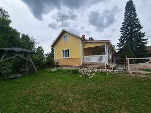 a yellow house with a porch on a yard at Pihatalo in Seinäjoki